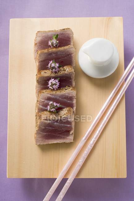 Верхний вид обожженного тунца с цветами на ломтиках хлеба — стоковое фото