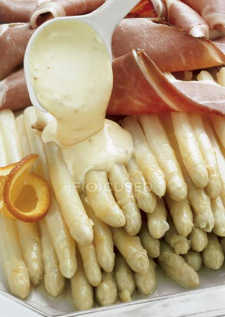 Asparagus with ham and white sauce — Stock Photo