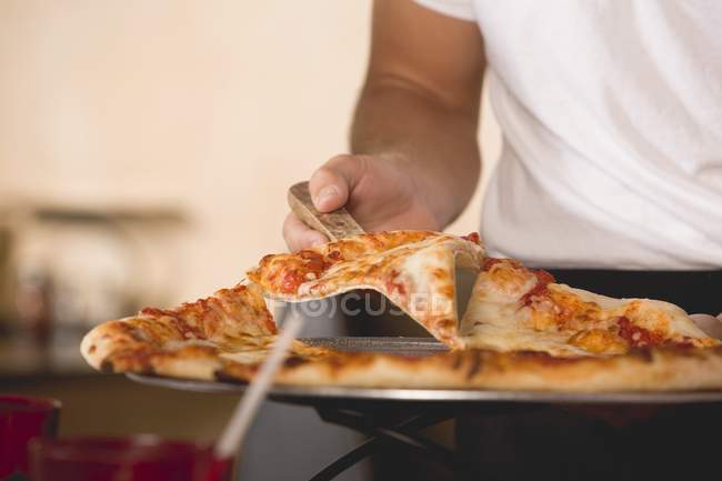Vista cortada de pessoa que serve pizza Margherita — Fotografia de Stock