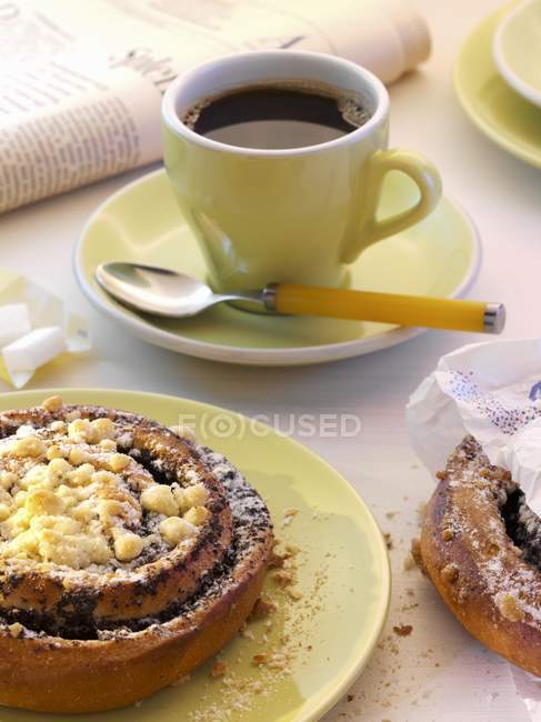 Vista de perto de pães de semente de papoula e uma xícara de café — Fotografia de Stock