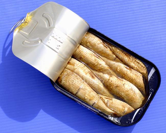 Closeup view of smoked sprats with oil in opened tin — Stock Photo