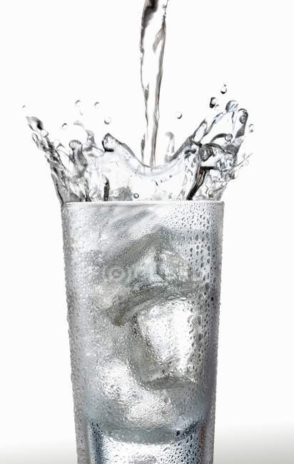 Verter agua en el vaso - foto de stock