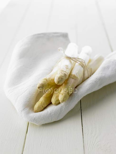 Белая спаржа на белой ткани — стоковое фото