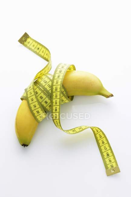 Banana con cinta métrica - foto de stock