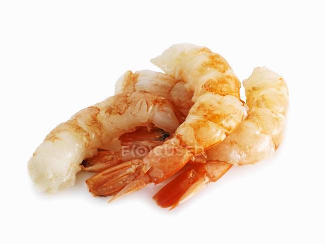 Vue rapprochée du tas de queues de crevettes cuites sur la surface blanche — Photo de stock