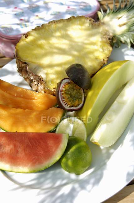 Frutas frescas en rodajas en el plato - foto de stock