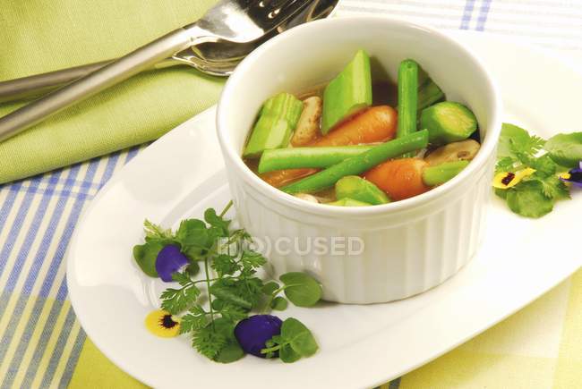 Рагу из овощей в белом горшке над тарелкой — стоковое фото