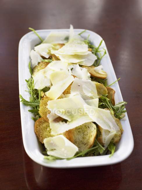 Vue rapprochée de la salade roquette et crostini au parmesan — Photo de stock