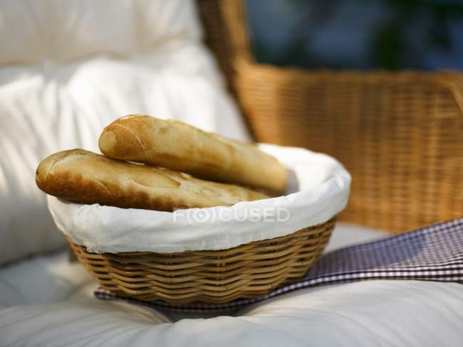 Baguettes frescos en cesta de pan - foto de stock