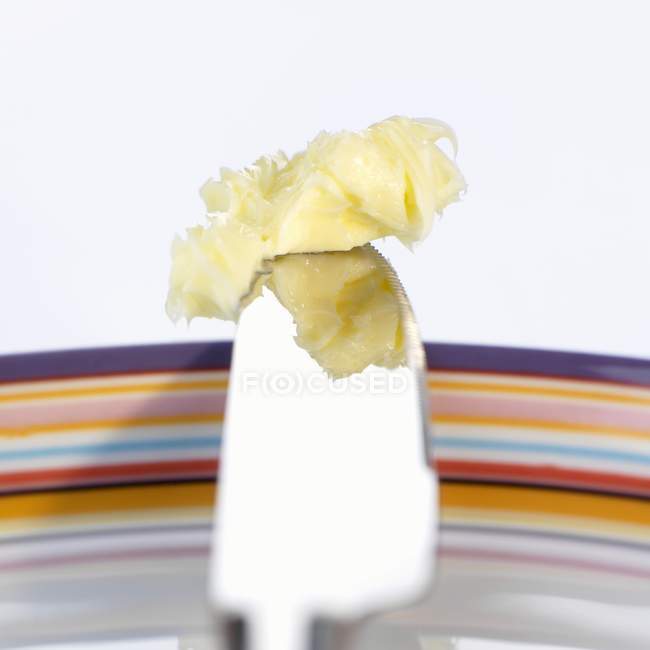 Vue rapprochée du beurre mou sur la lame du couteau — Photo de stock
