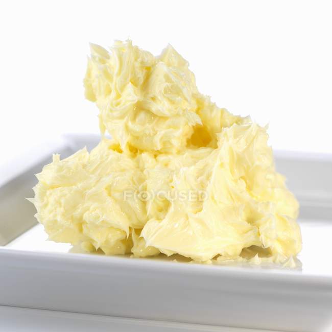 Vista close-up de manteiga macia na placa branca — Fotografia de Stock