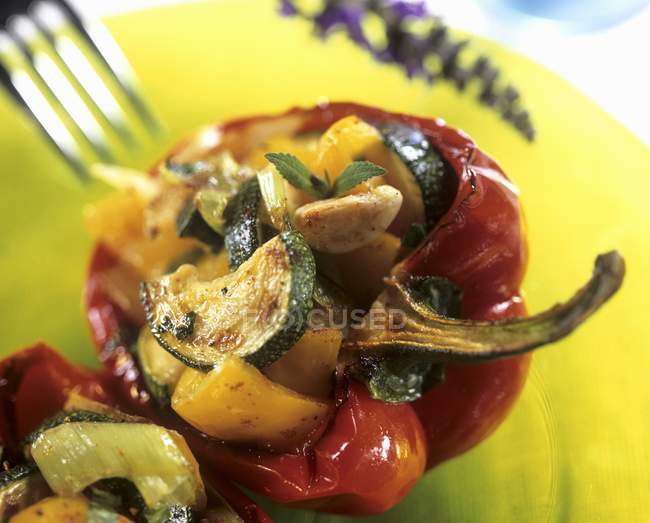 Pimienta rellena con relleno de verduras en el plato con tenedor - foto de stock