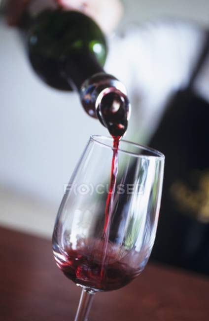 Pouring red wine into glass — Stock Photo