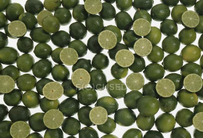 Fresh limes with halves — Stock Photo