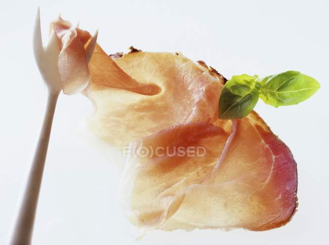 Fetta di prosciutto con erba su forchetta — Foto stock