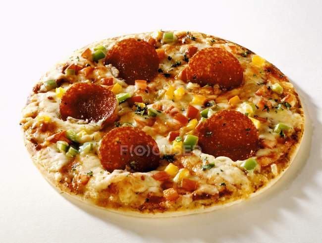 Pizza de salami con maíz dulce y verduras - foto de stock