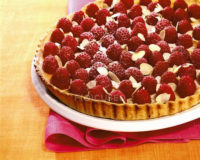 Raspberry tart with flaked almonds — Stock Photo