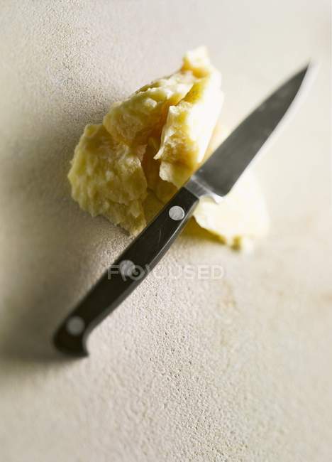 Parmesan with knife on white — Stock Photo