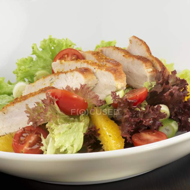 Vue rapprochée de la salade avec de la dinde tranchée et des légumes dans l'assiette — Photo de stock