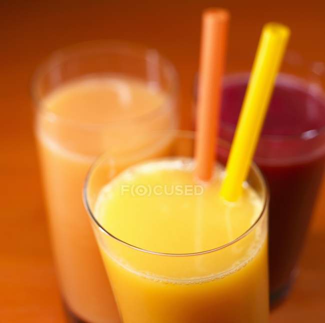 Апельсиновый сок с двумя соломинками — стоковое фото