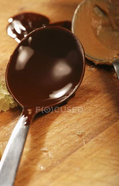 Closeup view of dark chocolate couverture in spoon — Stock Photo