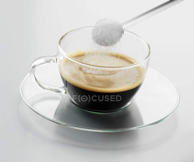 Putting sugar in espresso — Stock Photo