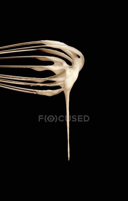 Closeup view of beaten icing on whisk — Stock Photo