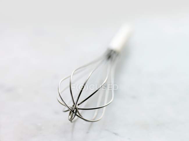 Closeup view of one whisk on white surface — Stock Photo