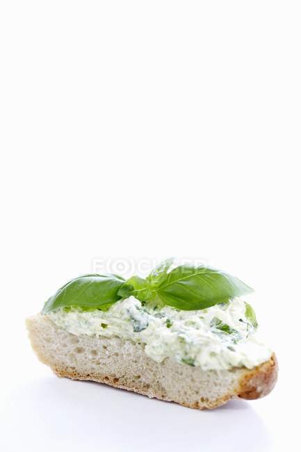 Courgette cream and basil on slice of white bread on white background — Stock Photo