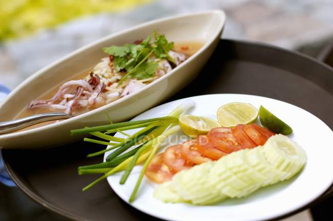 Крупный план каракатицы с нарезанными овощами, фруктами и травами — стоковое фото