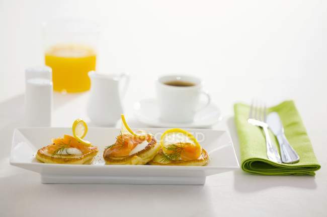 Blinis with sour cream and smoked salmon — Stock Photo
