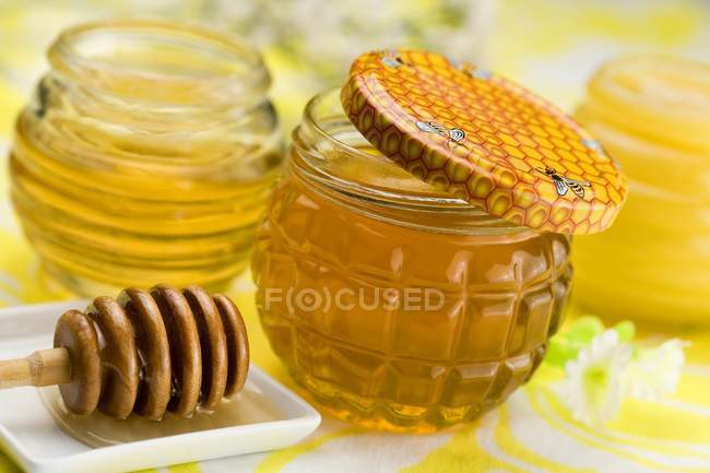 Jars of honey and dipper — Stock Photo
