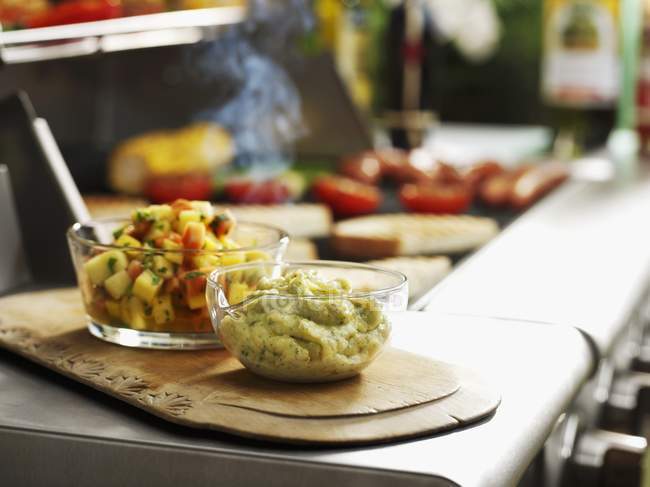 Grüne Tomaten-Chutney und Salsa in Glastöpfen über Holztisch — Stockfoto