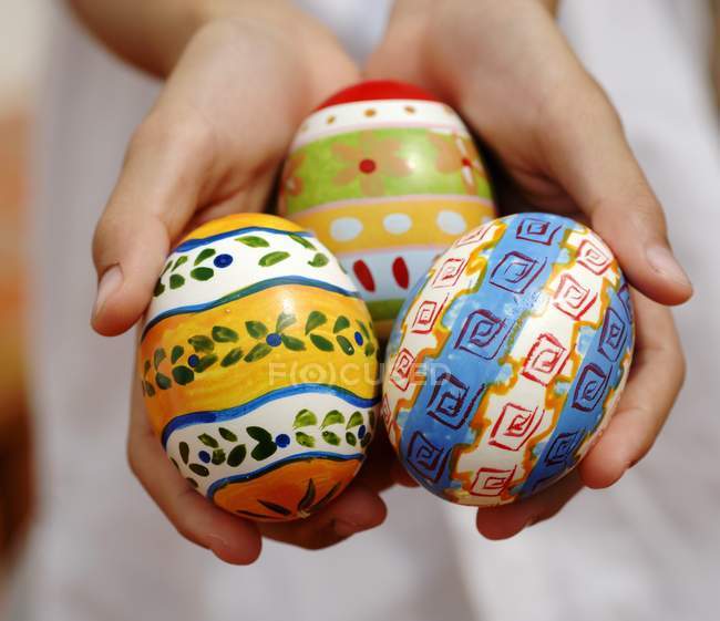 Manos de niño sosteniendo huevos - foto de stock