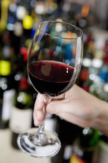 Hand holding glass of red wine — Stock Photo