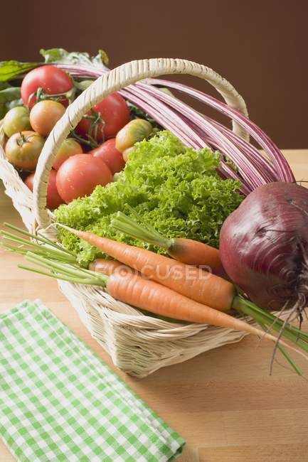 Салат и помидоры в корзине — стоковое фото