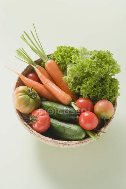 Морковь и салат в маленькой корзине — стоковое фото