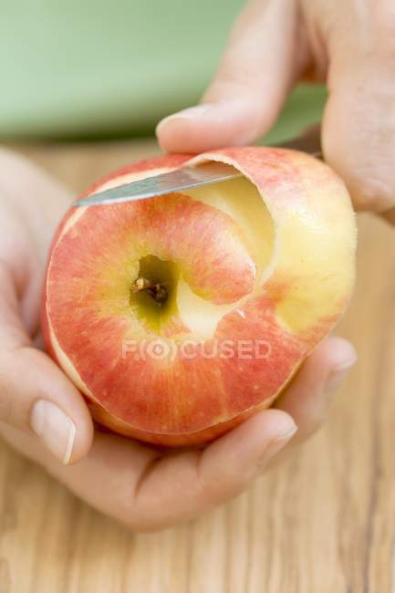 Manos femeninas pelar manzana - foto de stock