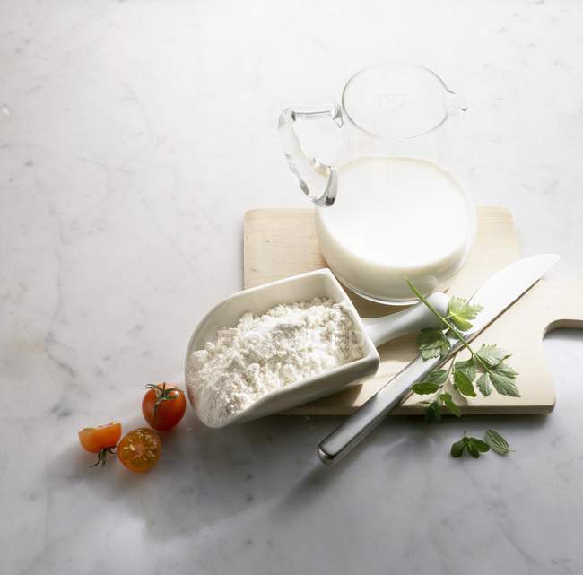 Jarro de leite e colher de farinha — Fotografia de Stock