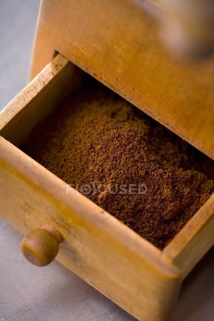 Vue rapprochée du café moulu dans le tiroir d'un vieux moulin à café — Photo de stock