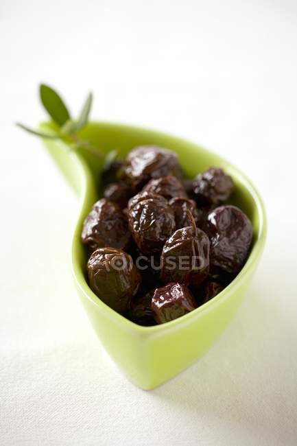 Yellow dish of black olives — Stock Photo