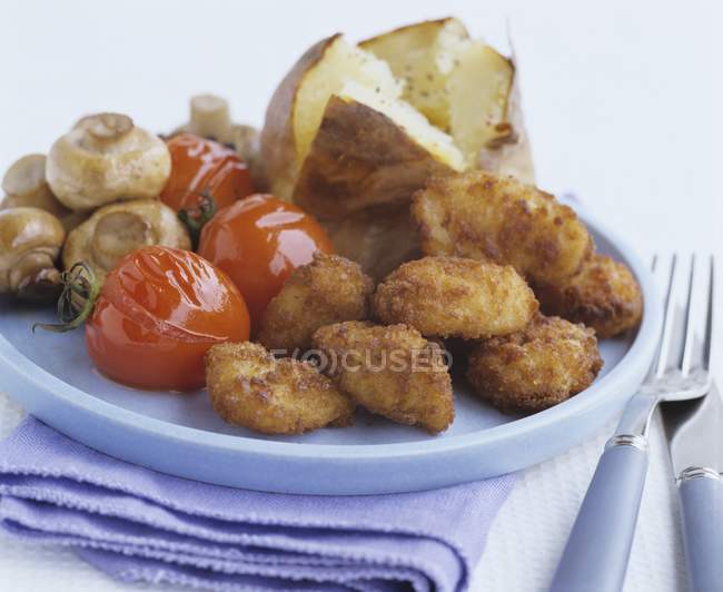 Pépites de poulet et pommes de terre cuites au four — Photo de stock