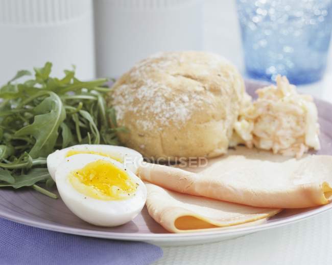 Ham with boiled egg and bread roll — Stock Photo