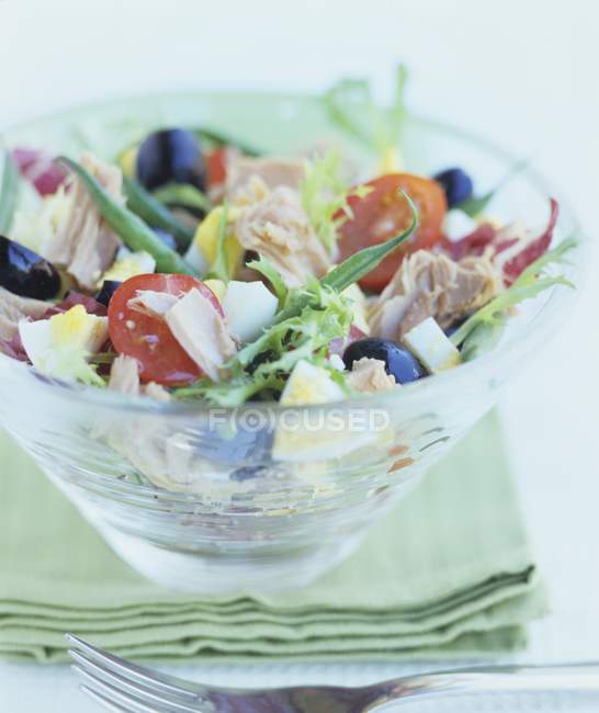 Salade nioise in glass bowl over towel — Stock Photo