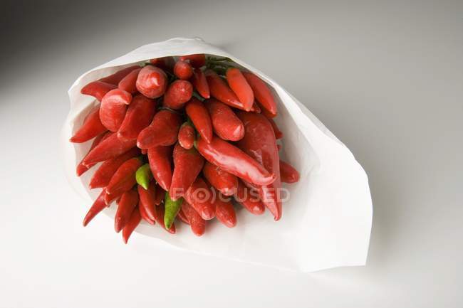 Chillies vermelhos em cone de papel — Fotografia de Stock