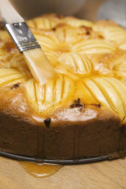 Brushing apple cake — Stock Photo