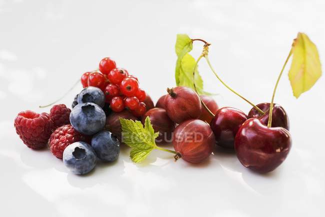 Três cerejas e frutas sortidas — Fotografia de Stock