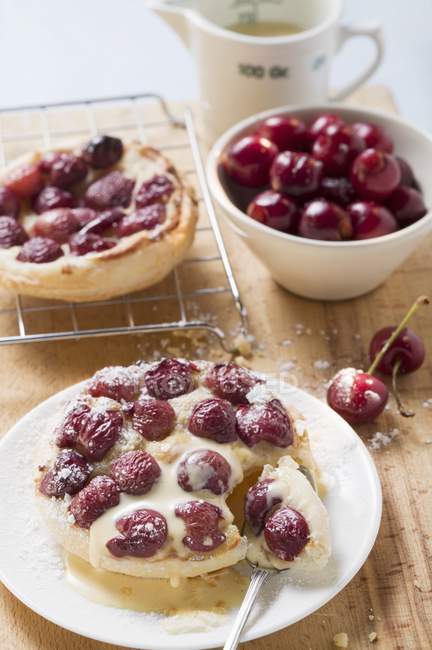 Cherry tart with icing sugar and custard — Stock Photo