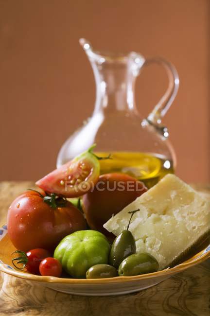 Оливки и пармезан на тарелке — стоковое фото