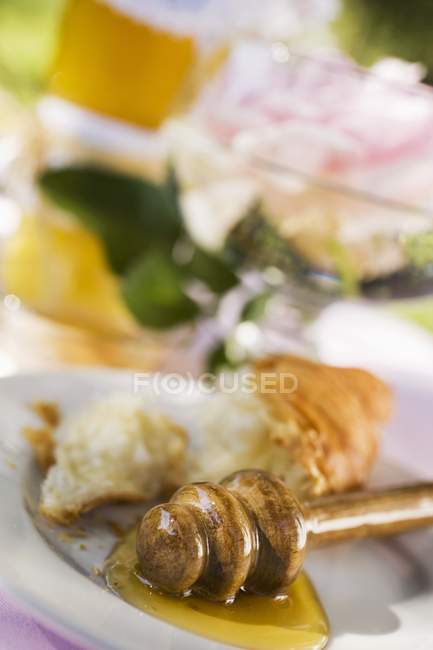 Dipper mel e restos de croissant — Fotografia de Stock